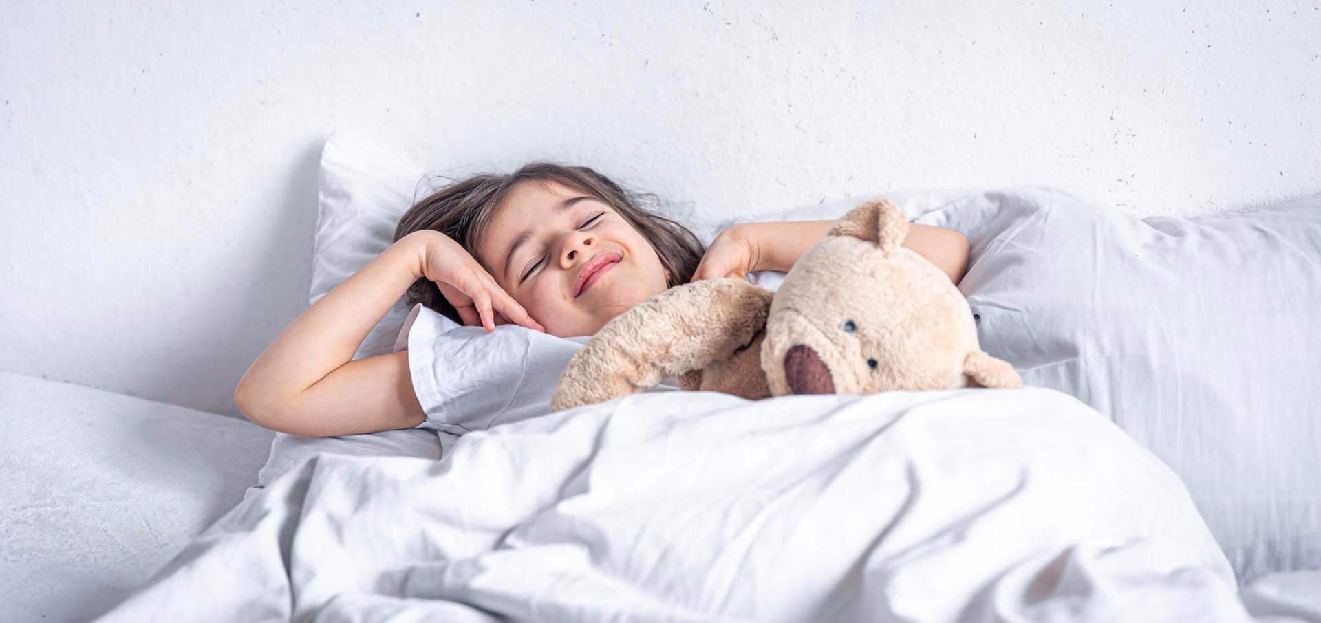 little cute girl bed with teddy bear early morning